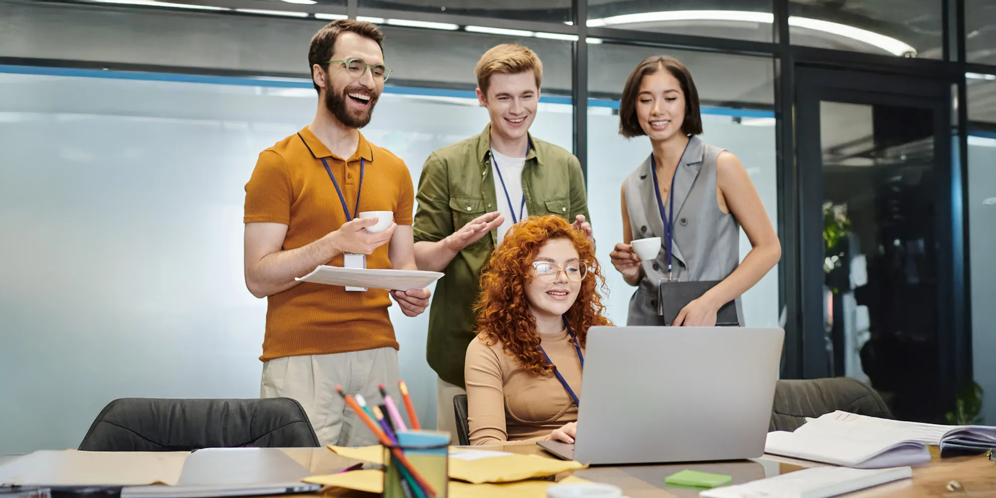 Cheerful business team gathered around a laptop in the office